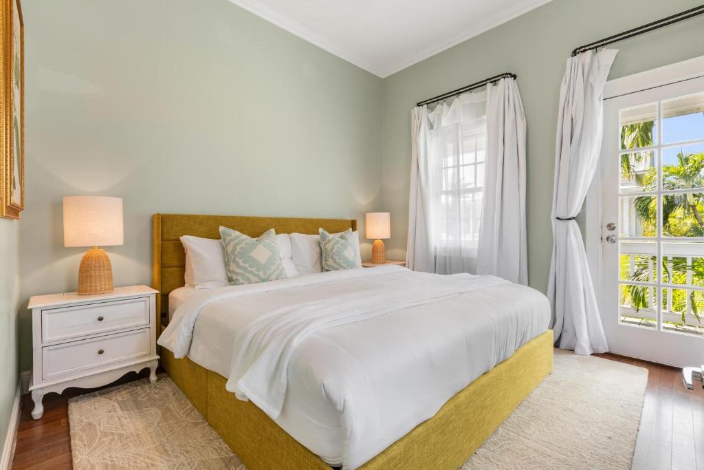 a white bedroom with a large bed and a window at CLARO at Azul Mansion Key West in Key West