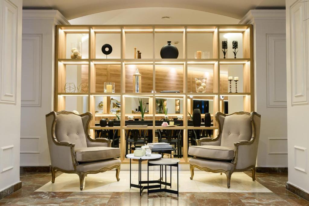 two chairs and a table in a room with shelves at Midtown Boutique Hotel in Buenos Aires