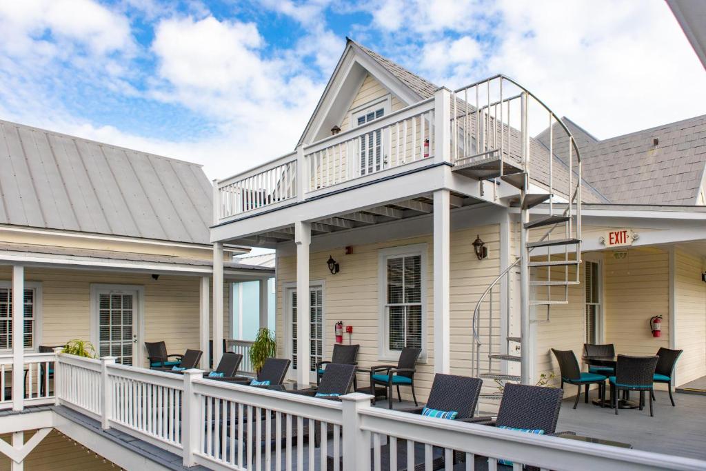 a deck with chairs and tables on a house at ARIA at Azul Mansion Key West in Key West