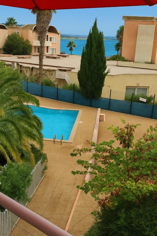 a view of a swimming pool from the balcony of a house at Le Thalassa I appartement T2 en bord de plage et du Port in Gruissan