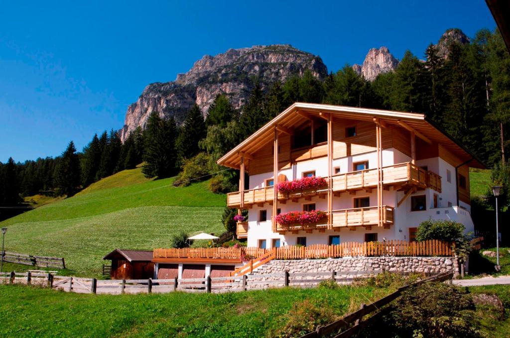 una casa en una colina con montañas en el fondo en Ciasa Col Cuch, en La Villa