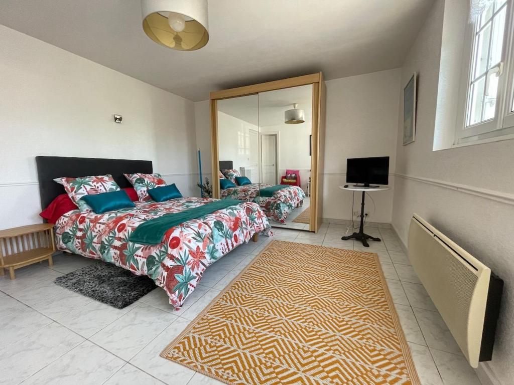 a bedroom with two beds and a mirror at Cosy one bedroom flat with terrace in Saint-Lunaire