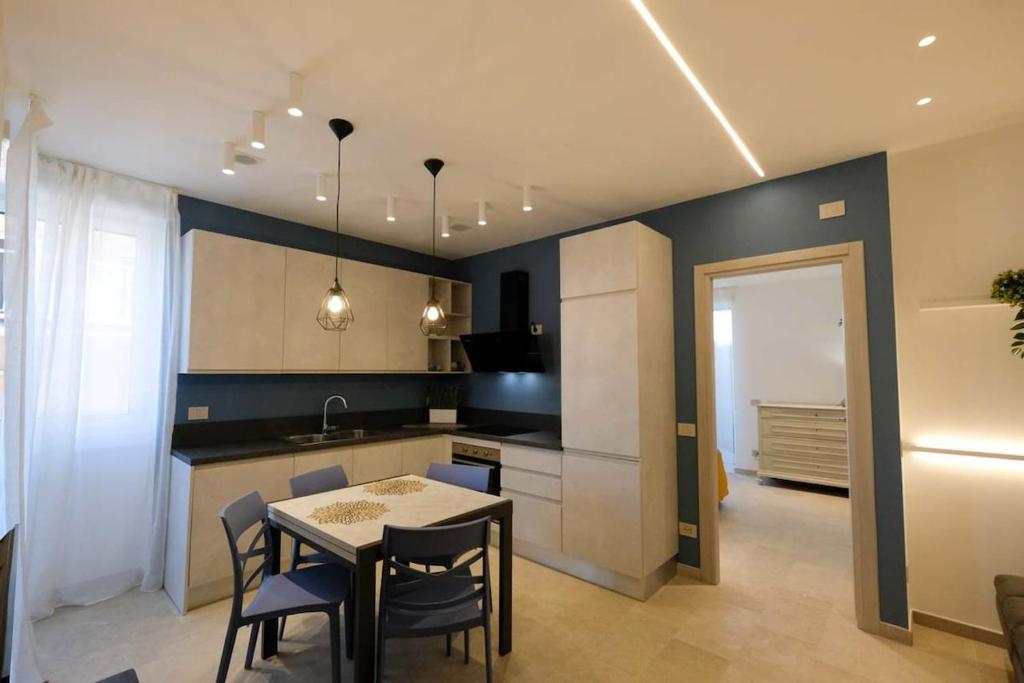 a kitchen with a table and chairs and a table and a kitchen at Blue Eagle - Villafranca Verona in Villafranca di Verona