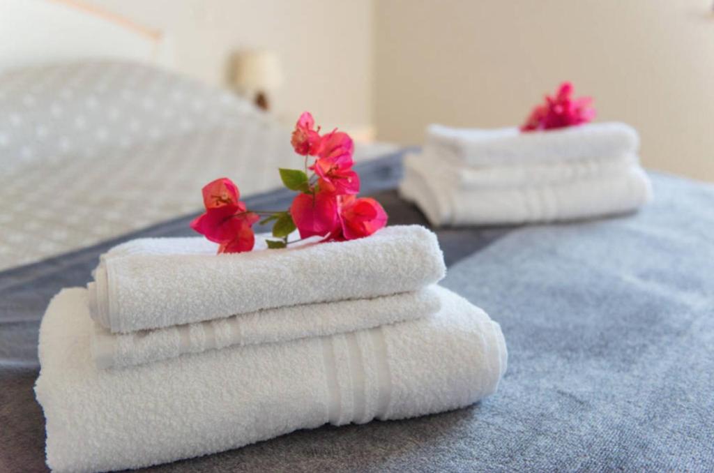 três toalhas com flores em cima de uma cama em Poetto Beach em Quartu SantʼElena