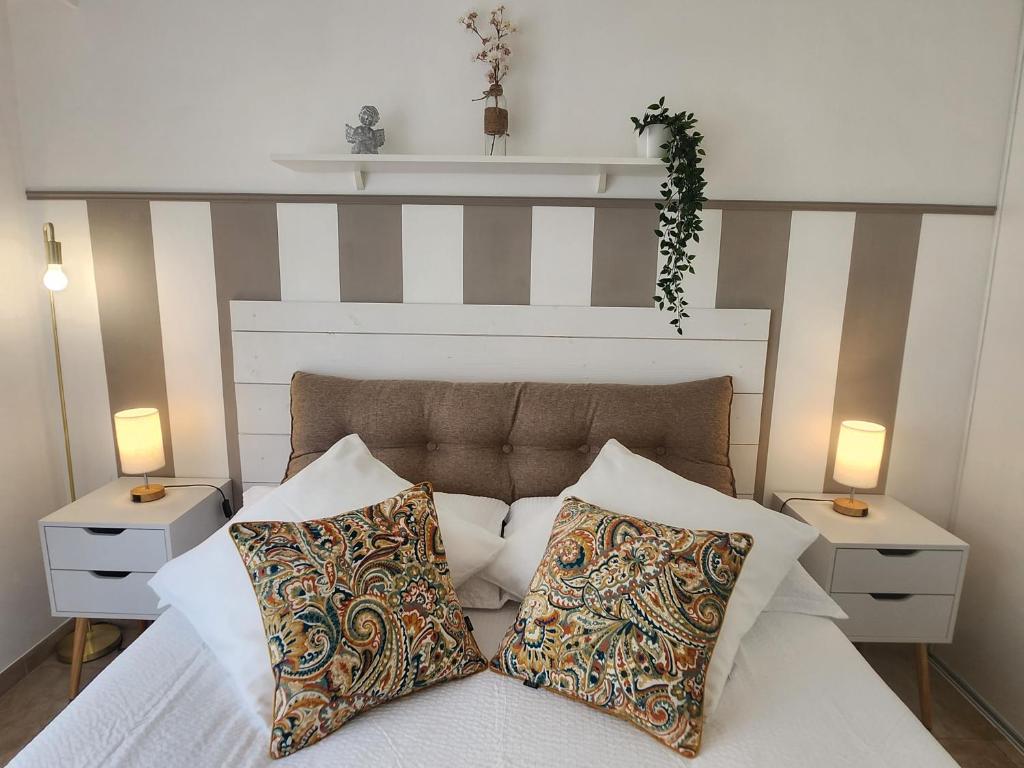 ein Schlafzimmer mit einem Bett mit zwei Nachttischen und zwei Lampen in der Unterkunft Cannes Paradis in Cannes