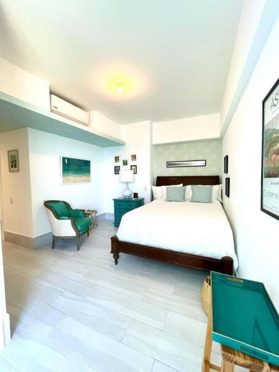 a bedroom with a large bed and a chair at Beachfront FL21 Con Tina Aquarella in La Puntica de Juan Dolio