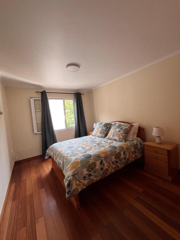 a bedroom with a bed and a window at Machico Village Apartment in Machico