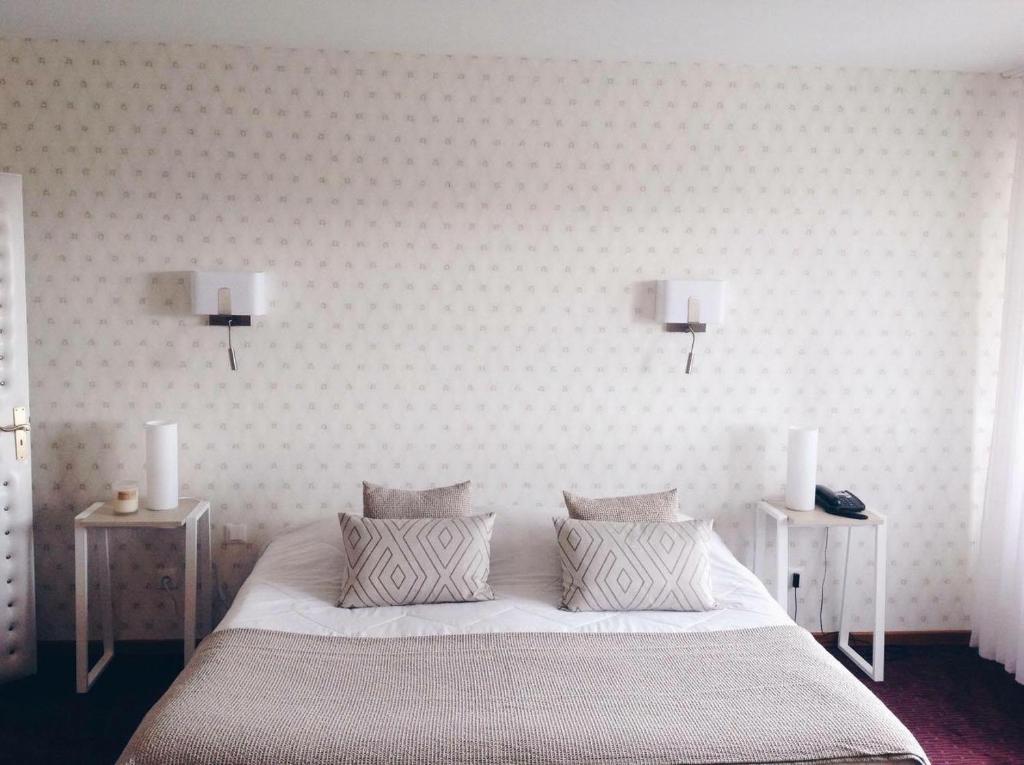a bed room with a white bedspread and white pillows at Relais Du Vignoble in Gueberschwihr