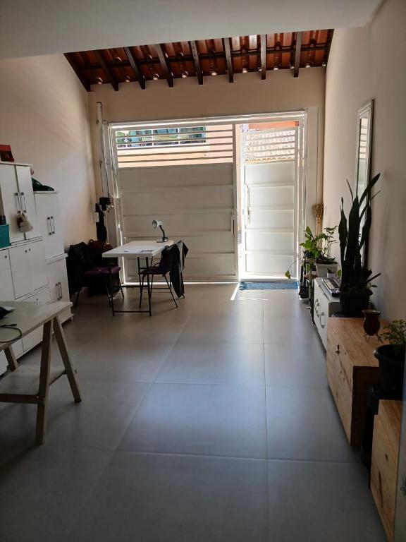 ein großes Wohnzimmer mit einem Tisch und einer Tür in der Unterkunft Hospedaria Transcendental - Mucugê-BA in Mucugê