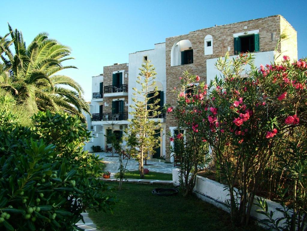 a building with trees and flowers in front of it at Archipelagos in Naxos Chora