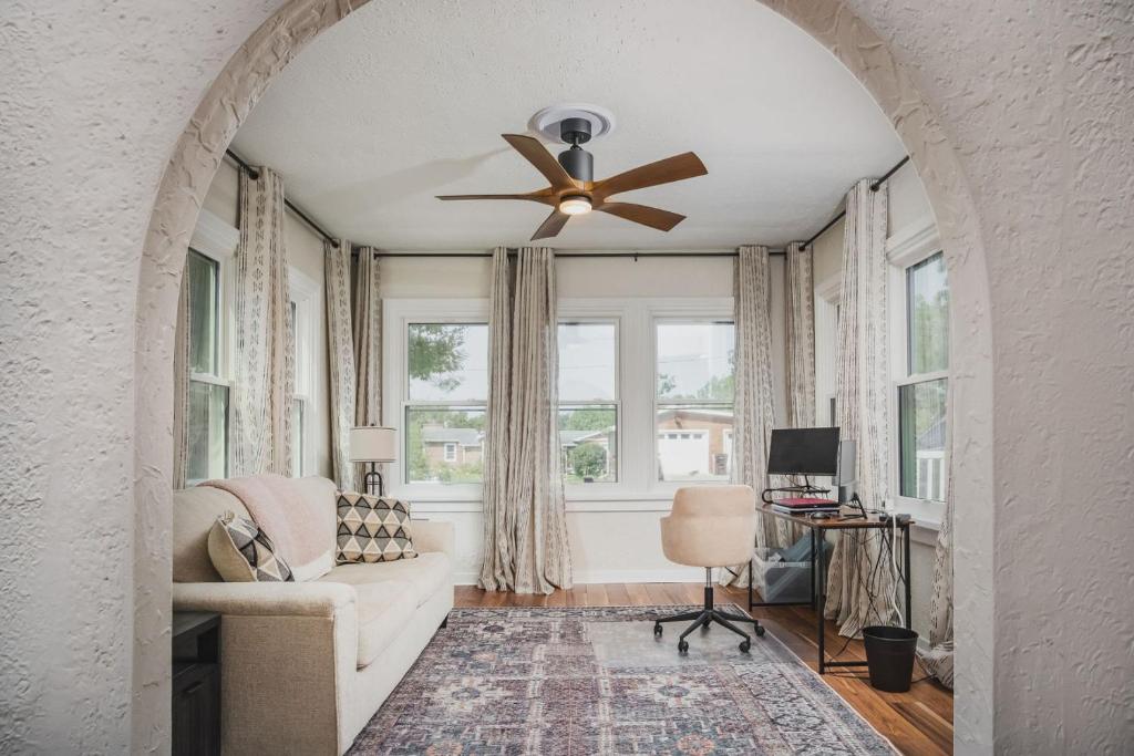 Whimsical Historic Getaway Near Golf Skiing and Wisconsin Southern Lakes في Genoa City: غرفة معيشة مع مروحة سقف وأريكة