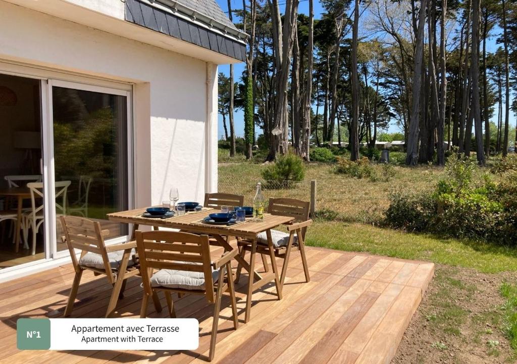 een houten tafel en stoelen op een terras bij La Villa du Bois d'Amour in Quiberon