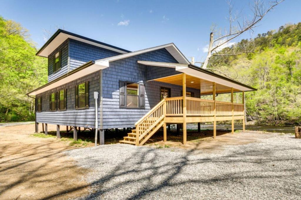 una casa blu con un grande portico e una casa di River Escape River Front Cabin a Tellico Plains