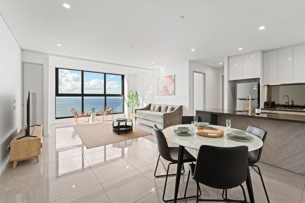 a kitchen and living room with a table and chairs at Oceanfront Luxury 2BR with Balcony and Views in Gold Coast