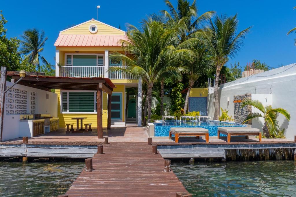 a house on the water with a dock at Marina Comodoro in Isla Mujeres
