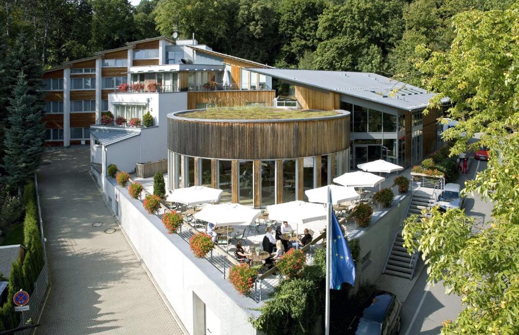 an aerial view of a hotel with tables and white umbrellas at Hotel Forsthaus Grüna in Chemnitz