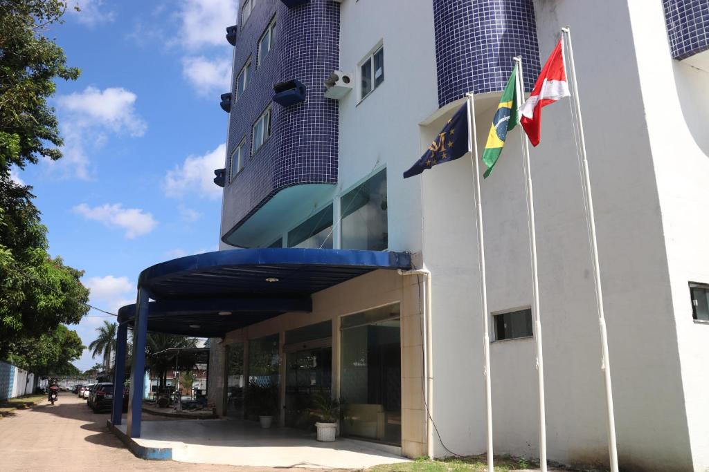 two flags flying in front of a building at GOLD MARTAN HOTEL in Belém