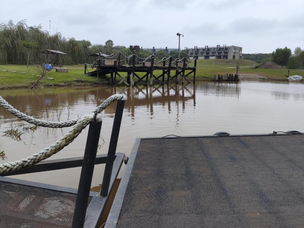 un muelle con una cuerda atada a un cuerpo de agua en amanecer de RIO y pesca, en San Pedro