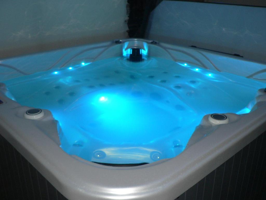 een blauw bad met verlichting in de badkamer bij La Mariennaye in Beaurepaire