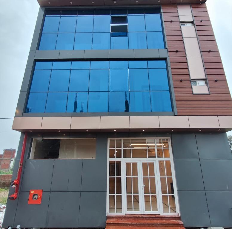 Un edificio alto de cristal con una puerta. en Hotel Ramayan Elite 2 KM Shree Ram Ji Mandir and Free Pickup From Ayodhya Dham Railway Station, en Ayodhya
