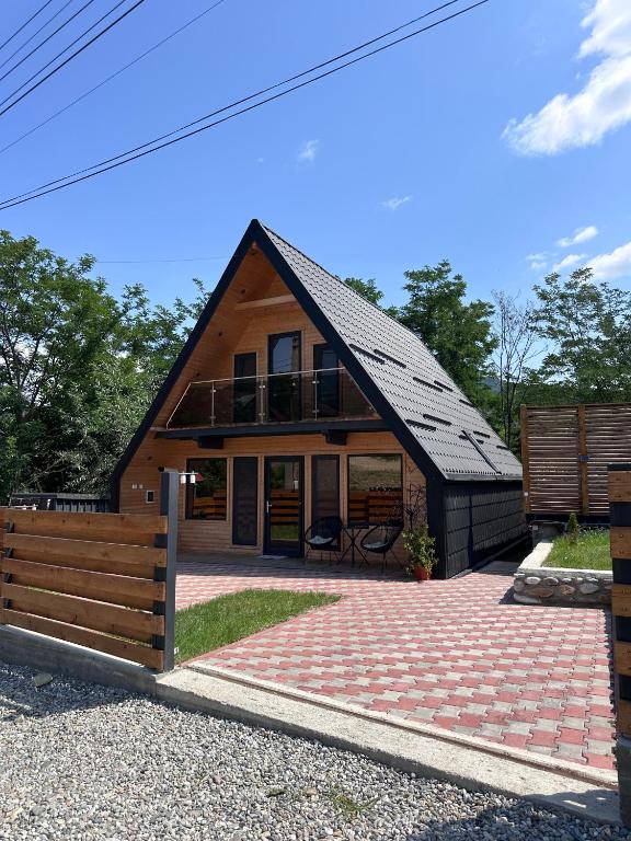 a house with a black roof and a brick driveway at LKS A-frame in Corbi