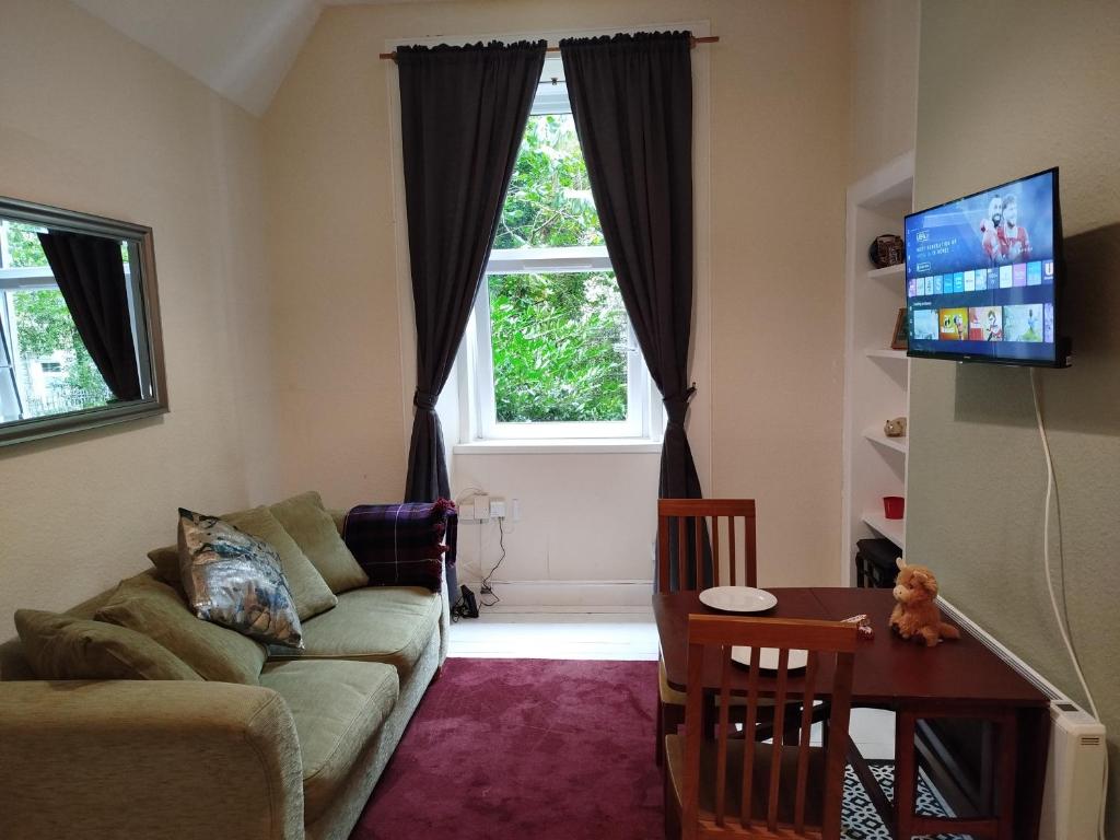 a living room with a couch and a table and a window at Lovely flat in Gorgie, Edinburgh in Edinburgh