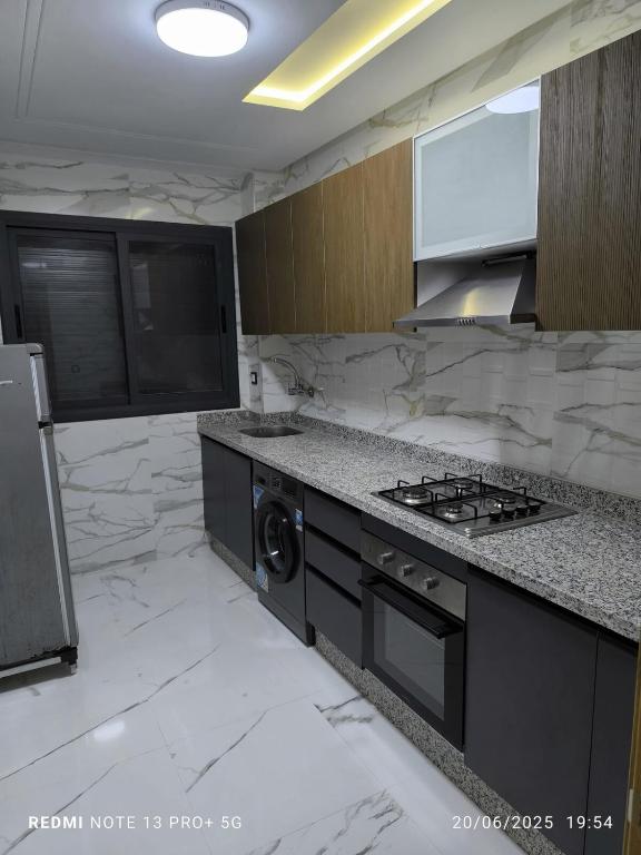 a kitchen with a stove and a washer at modern apartment in Tangier