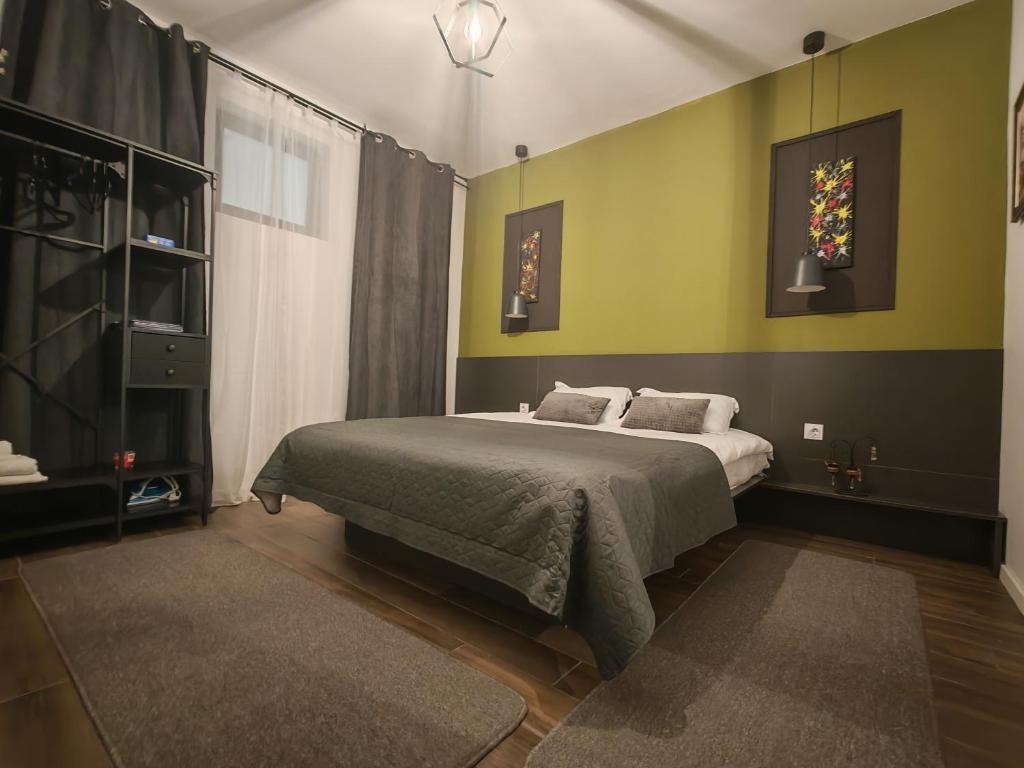 1 dormitorio con 1 cama grande y paredes verdes en Best City Green, en Craiova