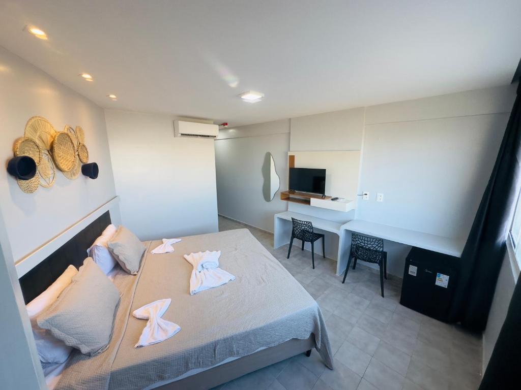 a hotel room with a bed and a desk at Barrudada Residence in Fortaleza