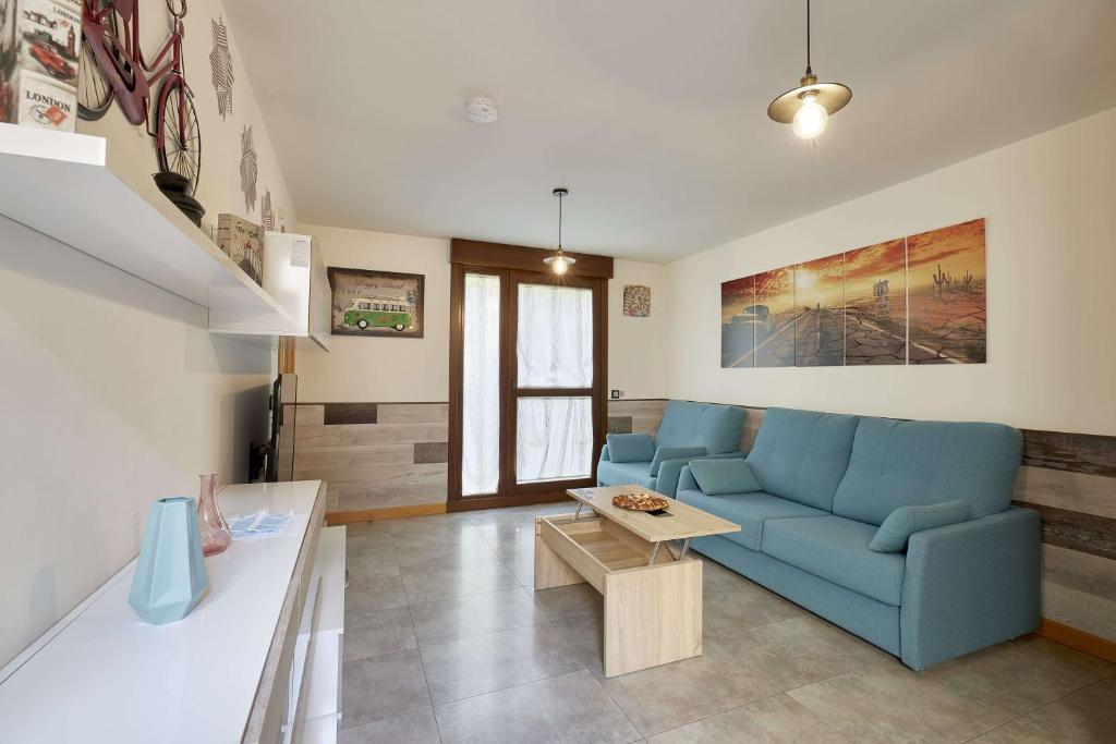 a living room with a blue couch and a table at El Patio de la Catedral in Salamanca