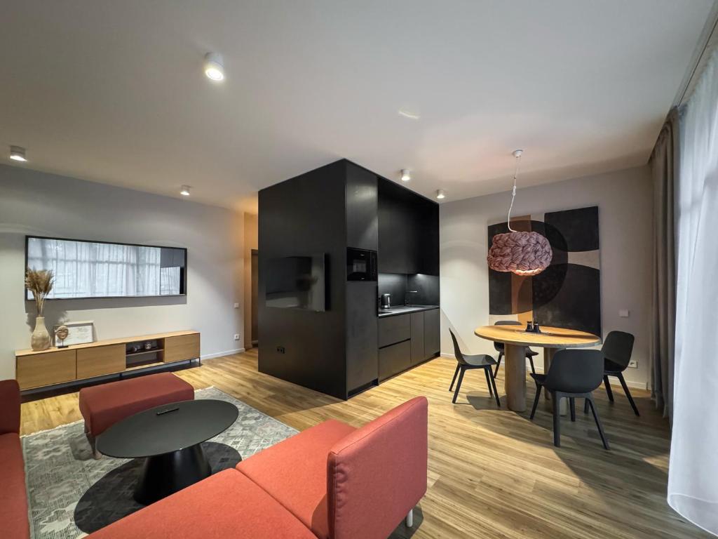 uma sala de estar com um sofá e uma mesa em Dzelzavas loft em Riga