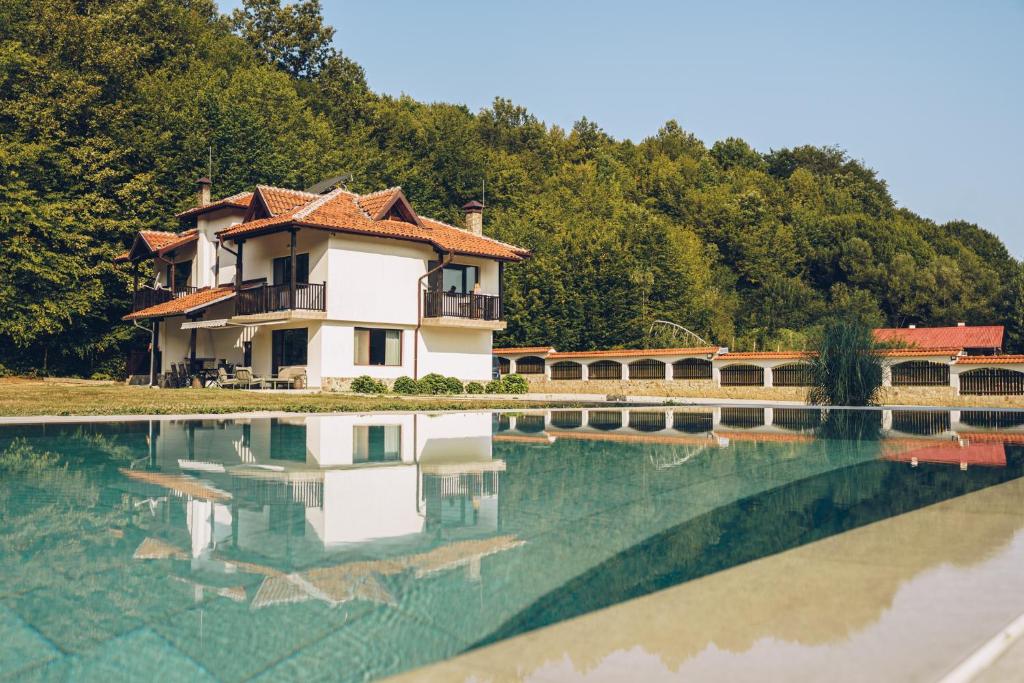 a house in the middle of a pool of water at Wildwood Villa in Apriltsi