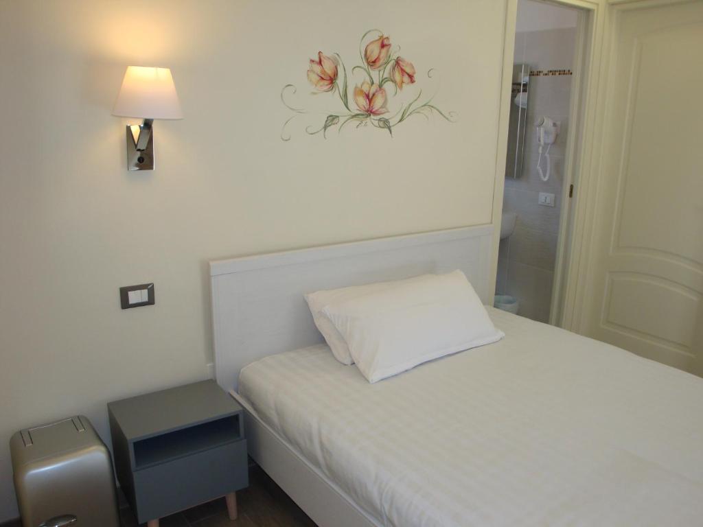 a small bedroom with a white bed and a lamp at Andoramare B&B in Marina dʼAndora