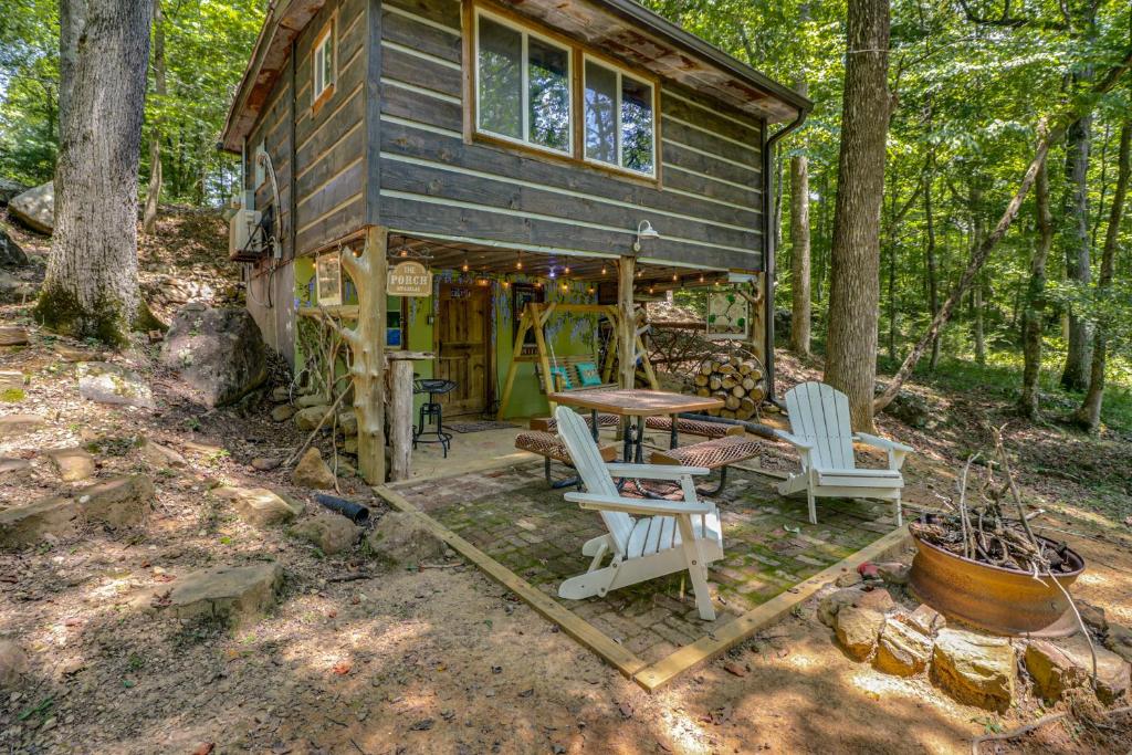 una pequeña casa en el bosque con una mesa y sillas en Creekside Retreat with Swimming Hole in Summerville, en Summerville