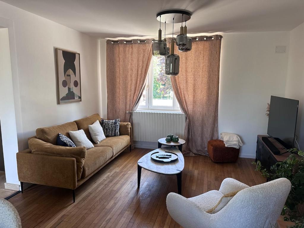 a living room with a couch and a table at Le Cocon de Vlinette in Brienne-le-Château