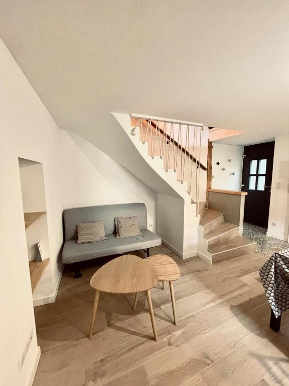 a living room with a couch and a staircase at La Petite Maison in Villargondran