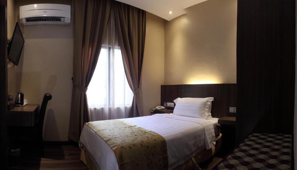 Postel nebo postele na pokoji v ubytování Mandarin Hotel Kota Kinabalu