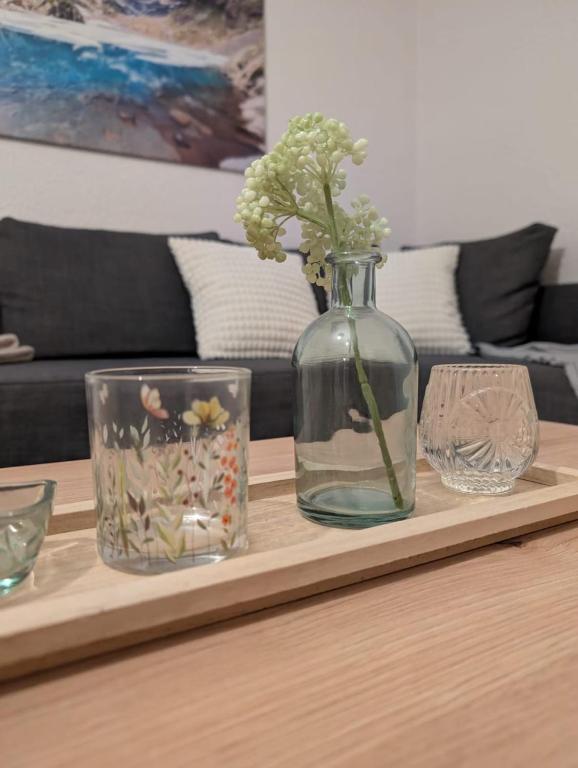 a table with a vase and two glasses on it at Ferienwohnung Landruhe in Katharinenberg