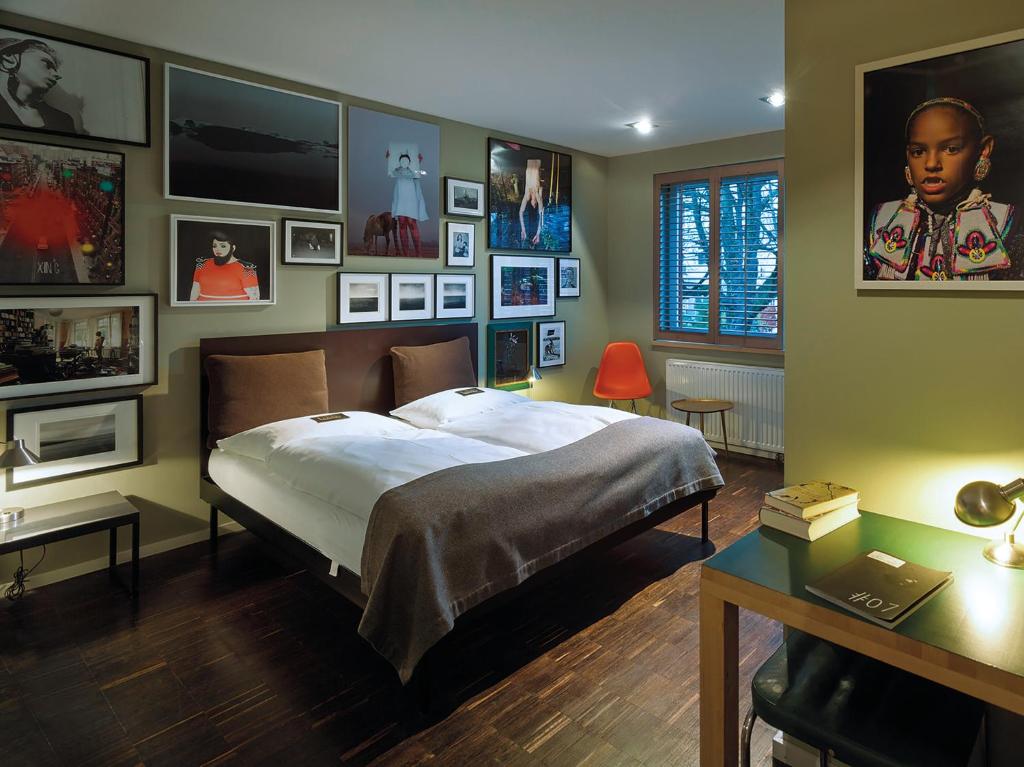 a bedroom with a bed and pictures on the wall at Das kleine Schwarze - Bed & Breakfast in Hamburg