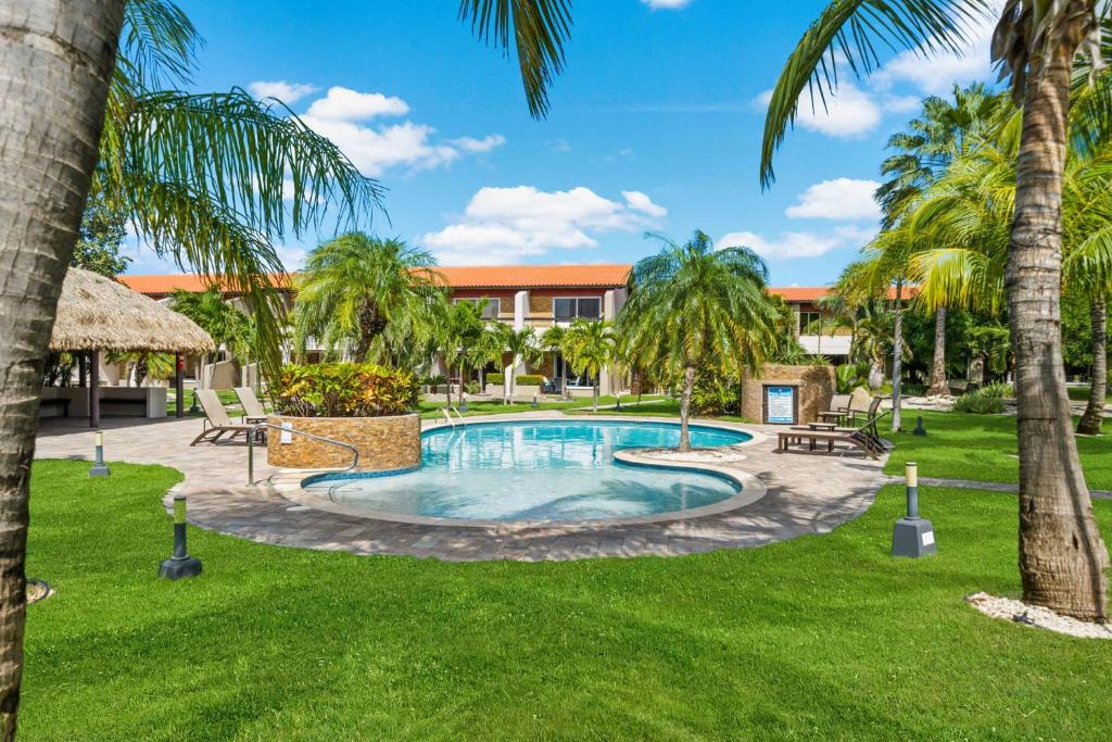 a pool in a yard with palm trees at Jardines del Mar 3 in Palm-Eagle Beach