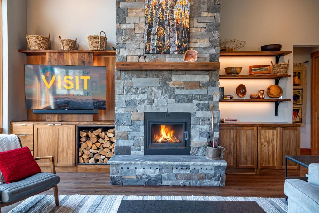 una sala de estar con chimenea de piedra en Luxury Ski Chalet - 684 Vasquez Road, en Winter Park