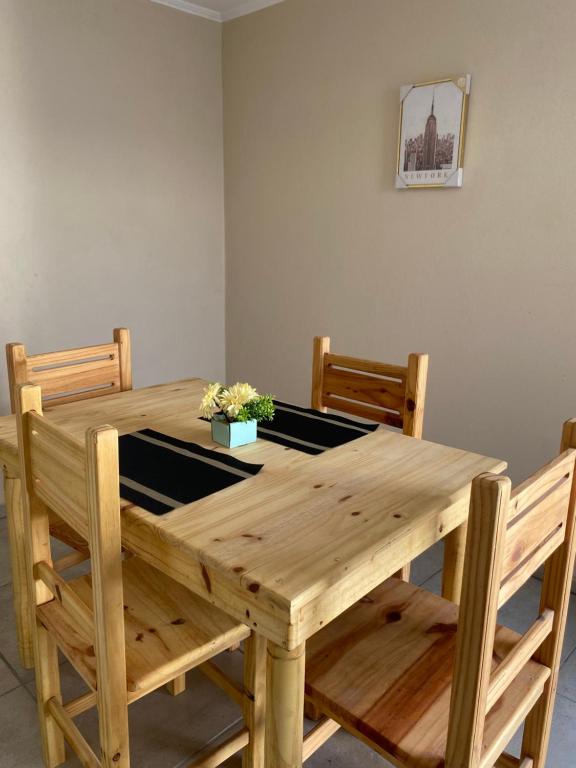 a wooden table with two chairs and a plant on it at Departamentos Belgrano in San Luis