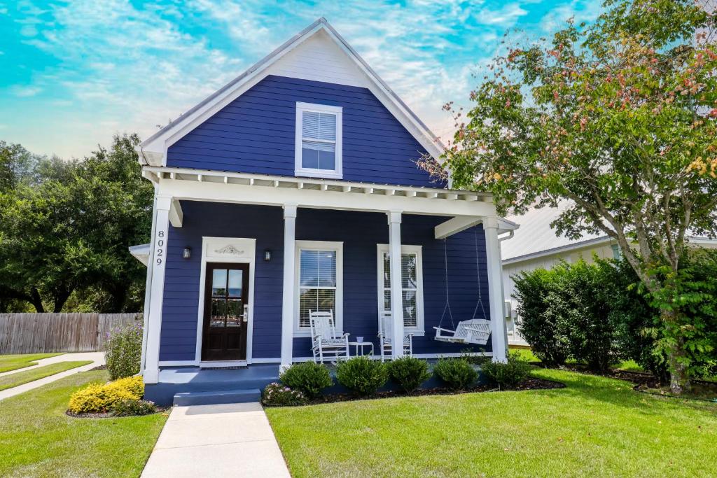 ein blaues Haus mit zwei Stühlen im Hof in der Unterkunft Cottage at Bella Vista in Foley