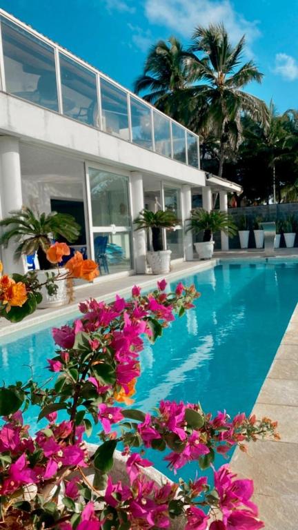 a swimming pool with flowers in front of a building at Vila Mar Hotel in Olinda