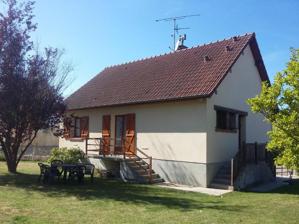 a small white house with a table and chairs at La Maison Trèfle in Vieux-Rouen-sur-Bresle