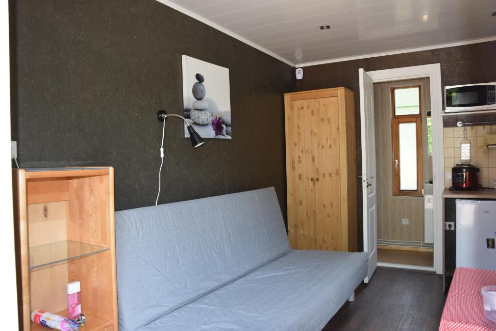 a small bedroom with a bed and a kitchen at Melluzi Cottage in Jūrmala