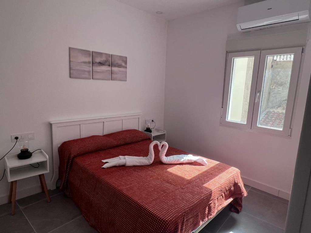 a bedroom with a bed with a white animal on it at Apartamento Rosina Ávila Center in Avila