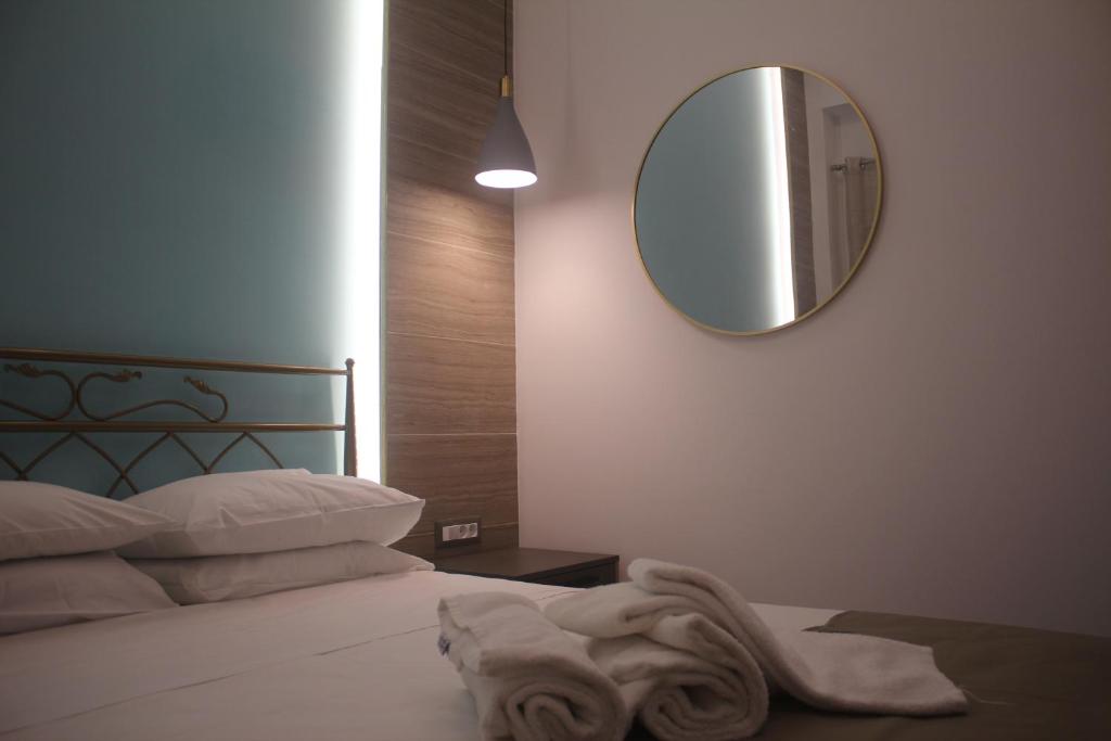 a bedroom with a bed with a mirror on the wall at Anemomilos View in Koskinou