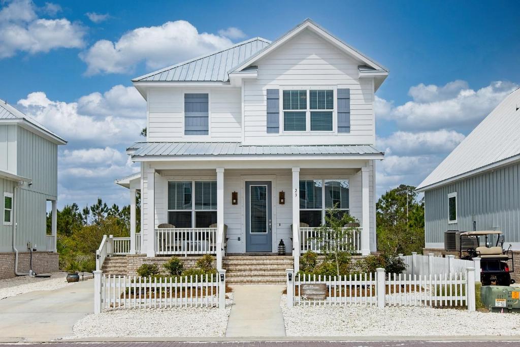 a white house with a white picket fence at Endless Summer in Gulf Shores
