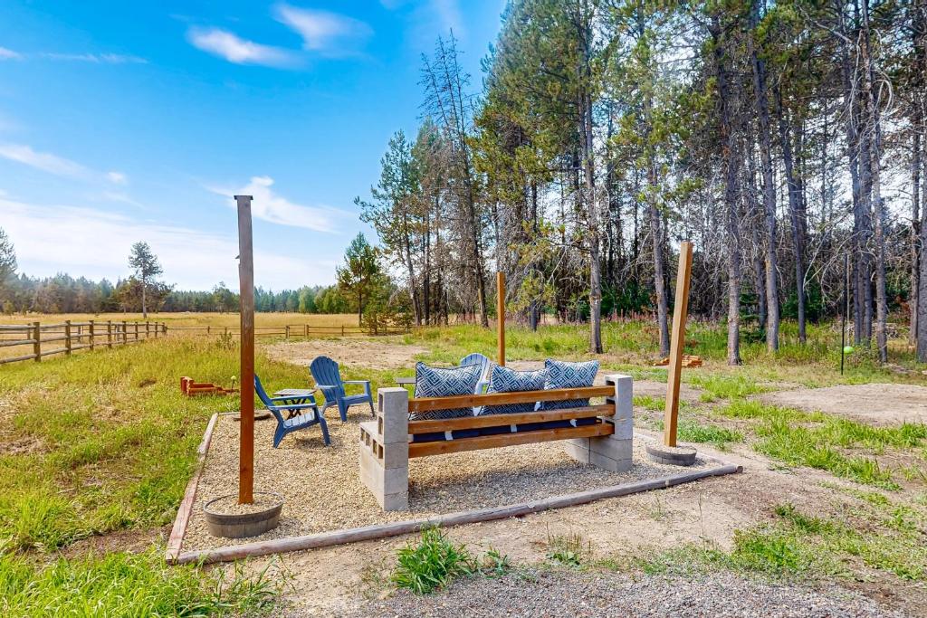 a park bench and two chairs in a field at Meadowpine Retreat in Donnelly